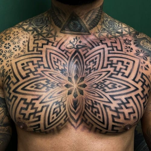 Geometric chest tattoo placed on the chest area, utilizing circular and geometric patterns to enhance body contours and create a visually striking design.