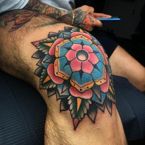 Geometric flower tattoo featuring a stylized floral design composed of geometric shapes and lines.