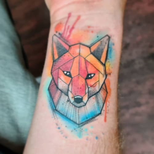 Geometric fox tattoo showcasing a fox head composed of geometric polygons, symbolizing intelligence and adaptability.