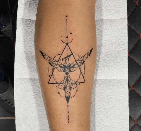 Geometric black ink tattoo on forearm with intricate symmetric design, featuring triangles and abstract elements.