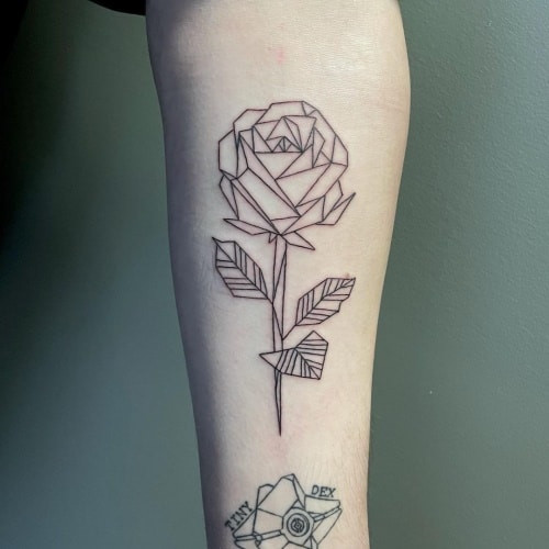 Geometric rose tattoo featuring a rose design constructed from geometric shapes and lines, blending classic beauty with modern geometry.