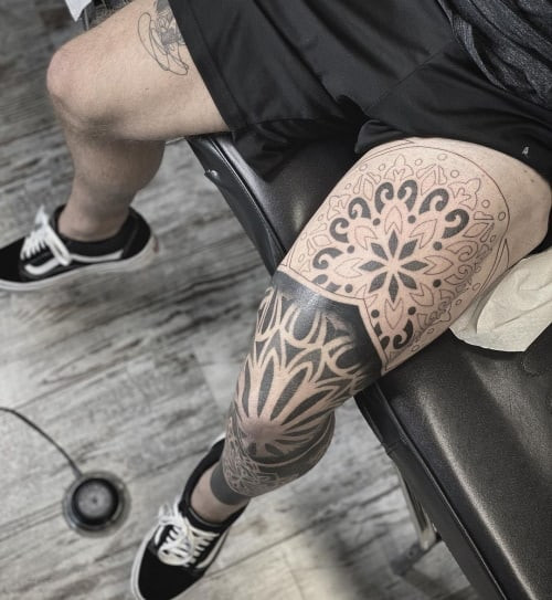 Geometric thigh tattoo located on the thigh, featuring geometric designs that are easily concealed but can be revealed with shorter clothing.