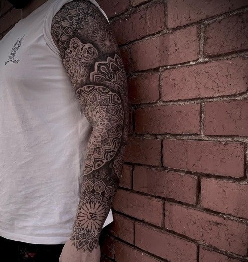 Geometric tattoo sleeve featuring a full arm sleeve with a variety of geometric patterns and shapes, showcasing the versatility of geometric tattoo art.