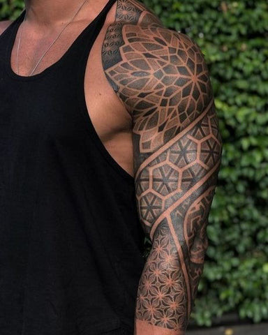 Geometric sleeve tattoo featuring intricate patterns of lines, shapes, and dots in black ink