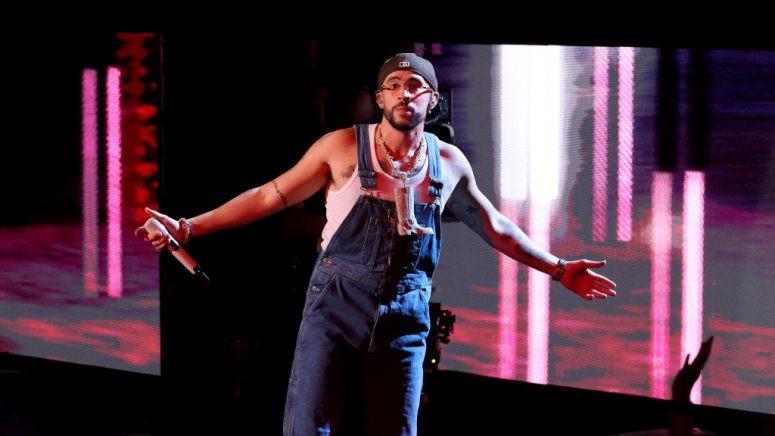 Bad Bunny performing on stage, showcasing his evolving tattoo collection.