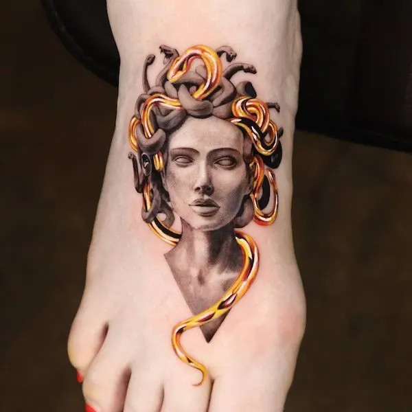 Golden Medusa foot tattoo, symbolizing confidence, strength, and mythical power from Greek mythology