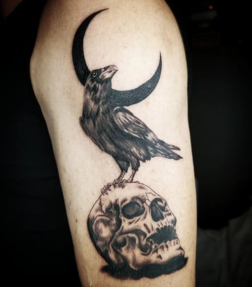 A gothic skull tattoo with dark shading on a man's arm, mysterious and edgy