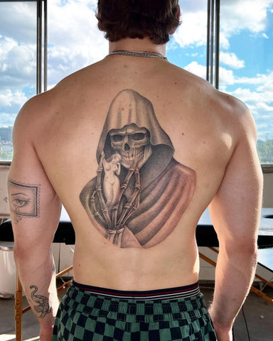 Eerie grim reaper tattoo for men with a hooded figure and scythe across the back, symbolizing mortality and fate.