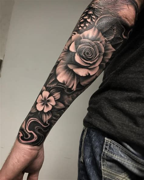 Detailed black and gray half sleeve tattoo of a skull and roses, showcasing intricate shading and realism.