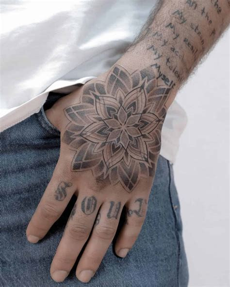 Man showcasing finger tattoos and a hand piece