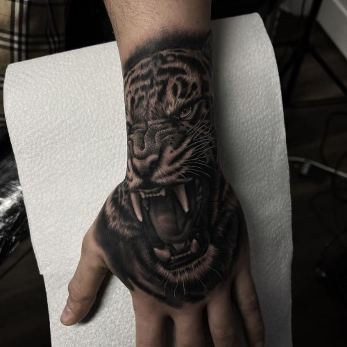 Hand tattoo with a geometric design covering the entire hand, a bold men tattoo idea.