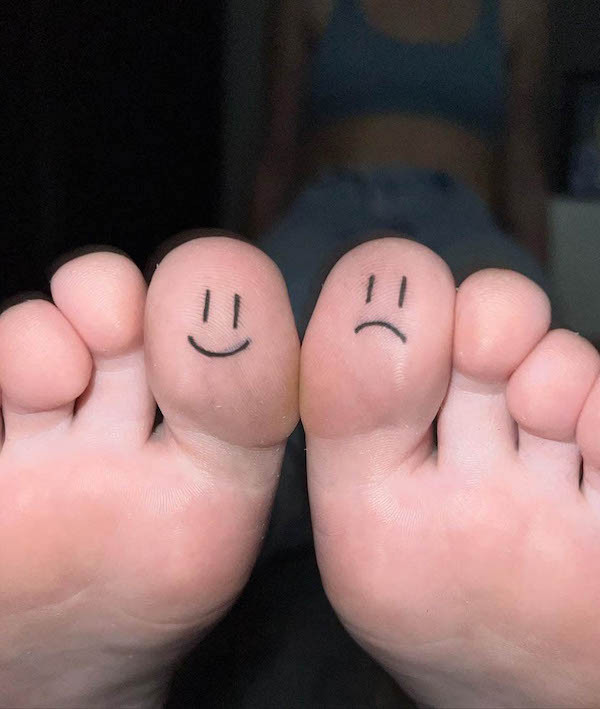 Happy face and sad face toe tattoos, a reminder to embrace all emotions, both positive and negative