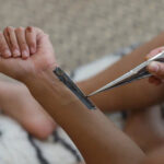 Woman applying organic henna paste to stencil