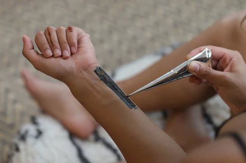 Woman applying organic henna paste to stencil