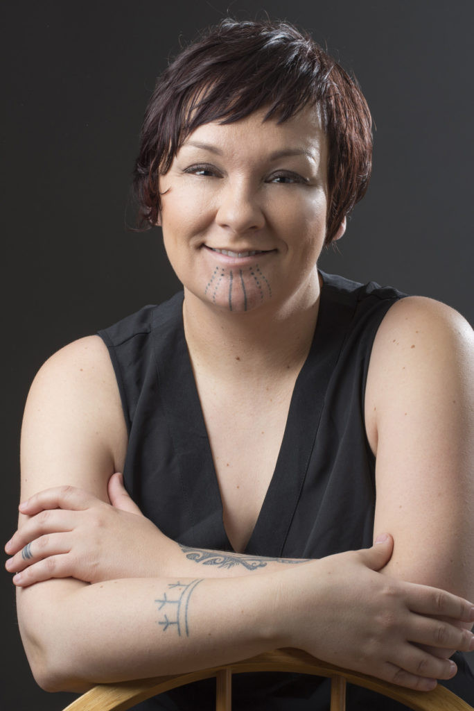 Holly Mititquq Nordlum, an Inupiaq artist, stands confidently, showcasing her traditional Inuit facial tattoos.