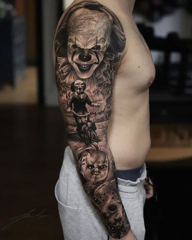 Horror sleeve tattoo featuring skulls, zombies, and haunted houses in dark and gruesome detail