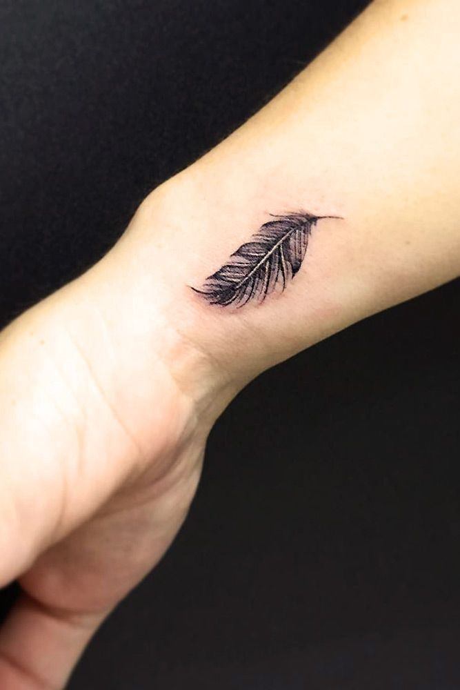 Detailed black feather wrist tattoo for women