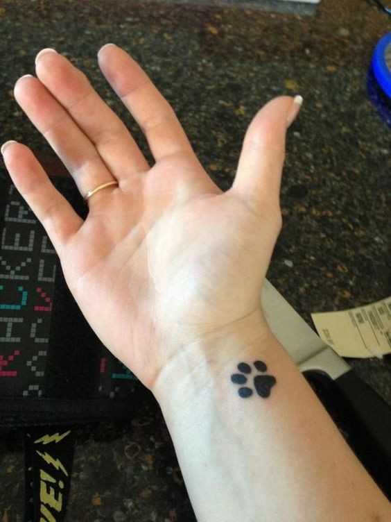 Cute paw print wrist tattoo, honoring pets and love for animals for women