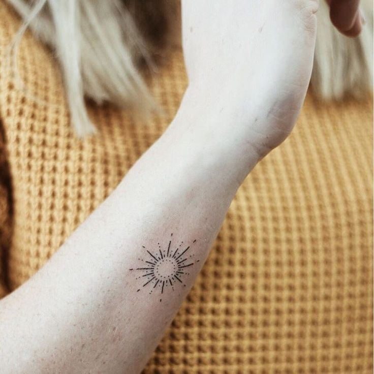 Radiant sunburst wrist tattoo, symbolizing energy, positivity, and warmth for women