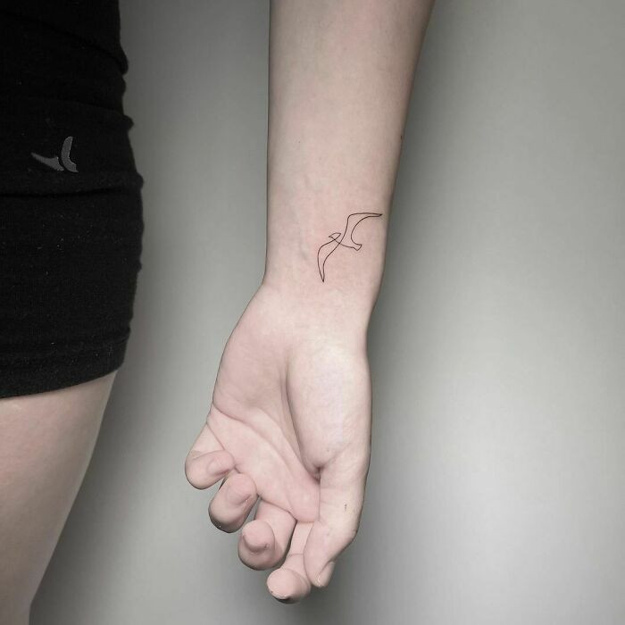 Modern single line art wrist tattoo, a minimalist and sophisticated abstract design for women