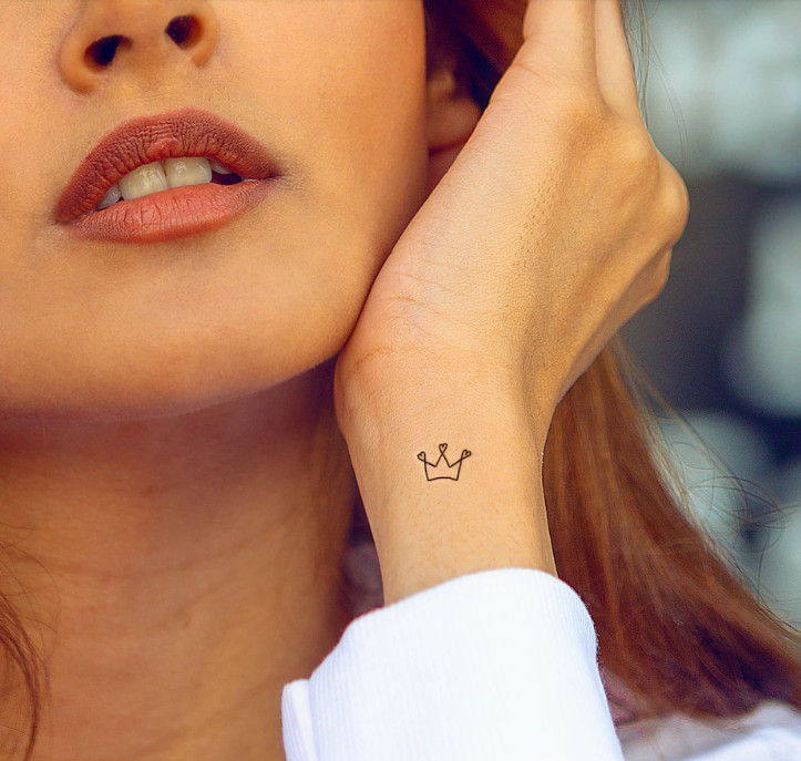 Small black crown wrist tattoo for women