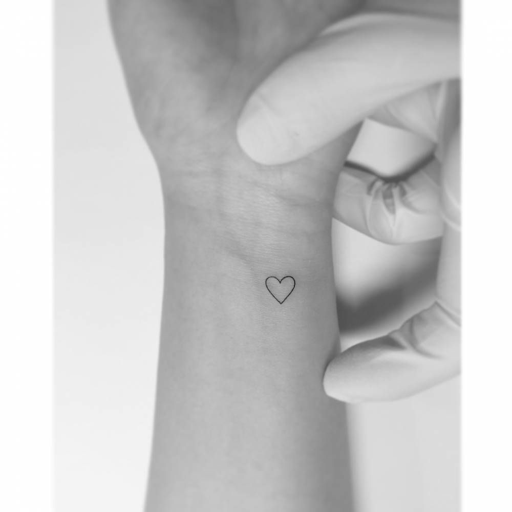 Fine line heart outline wrist tattoo for women