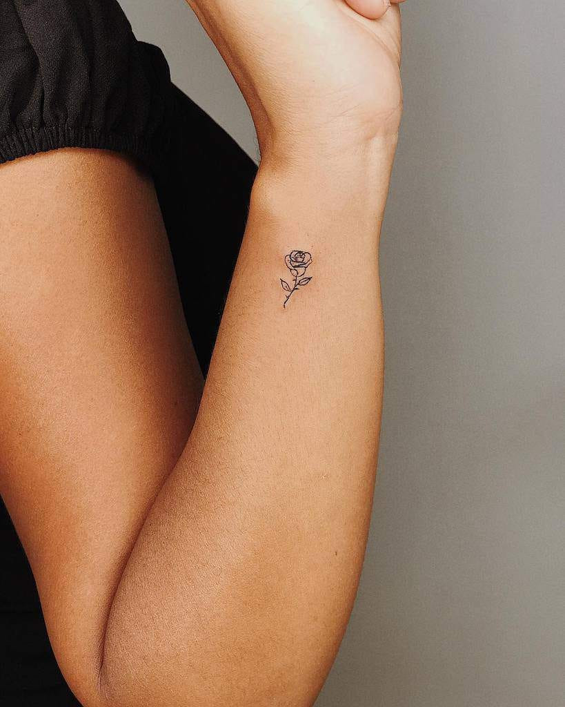 Delicate tiny rosebud wrist tattoo, a feminine and elegant symbol of budding beauty for women