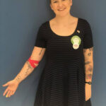 Enthusiastic blood donor, Sam, pictured in a blood donation center post-donation, demonstrating that individuals with tattoos can safely donate blood at American Red Cross facilities in regulated states.