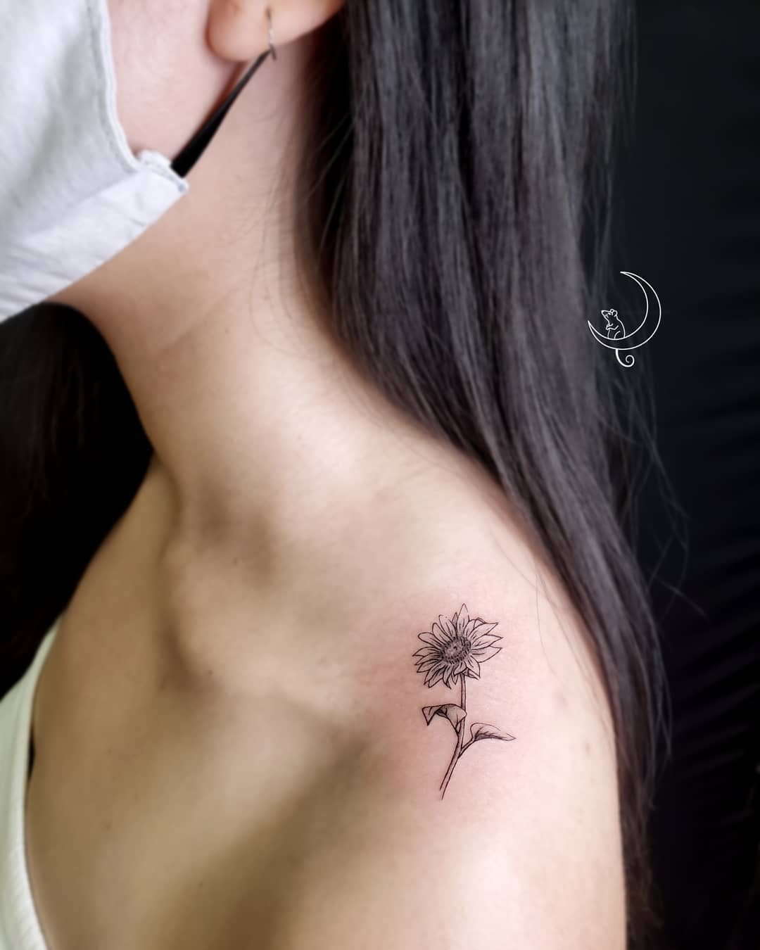 A cheerful sunflower tattoo on the top of the shoulder, radiating positivity.