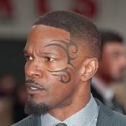 Close-up of Jamie Foxx's head tattoo featuring bold, black tribal lines along his hairline.