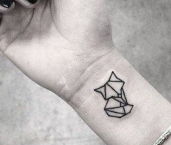 A geometric style fox tattoo in black ink on a wrist.