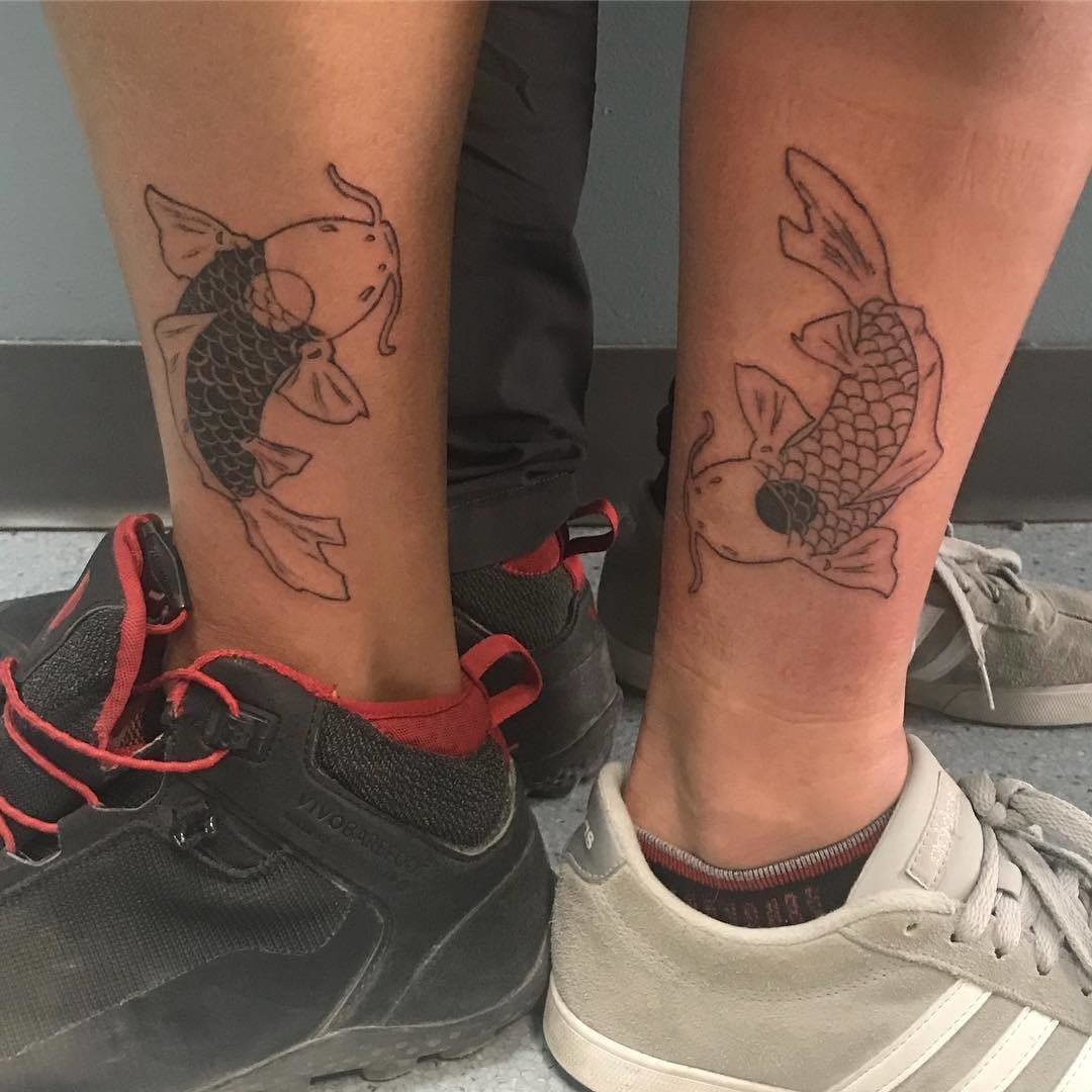 Father and daughter showcasing forearm tattoos of yin and yang koi fish designs, symbolizing harmony, balance, and their complementary relationship.