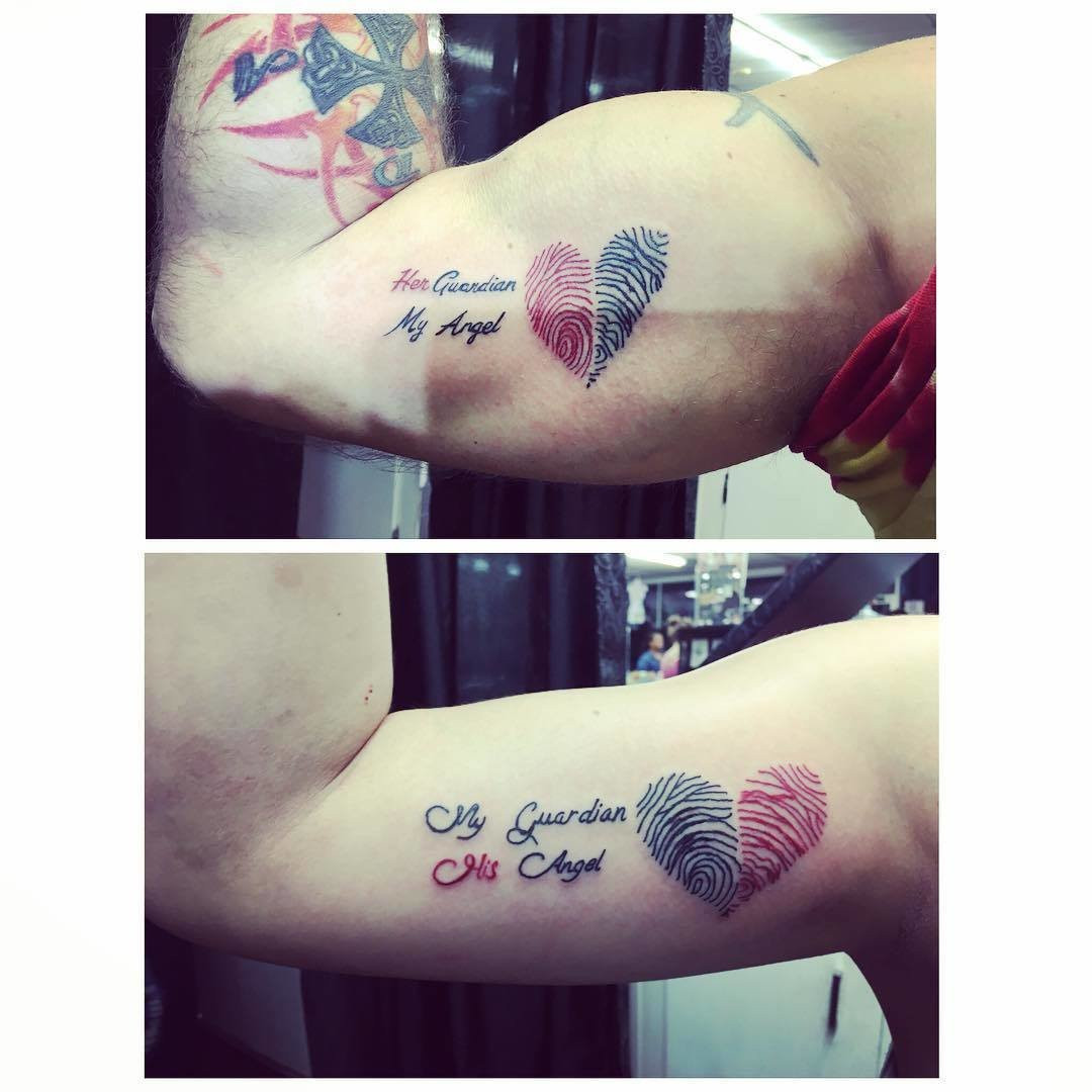 Father and daughter displaying forearm tattoos of thumbprint designs in two colors, creating a unique and intimate minimalist tattoo.