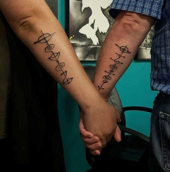 Father and daughter showcasing matching Star Trek insignia tattoos on their wrists, symbols of unity and shared fandom.