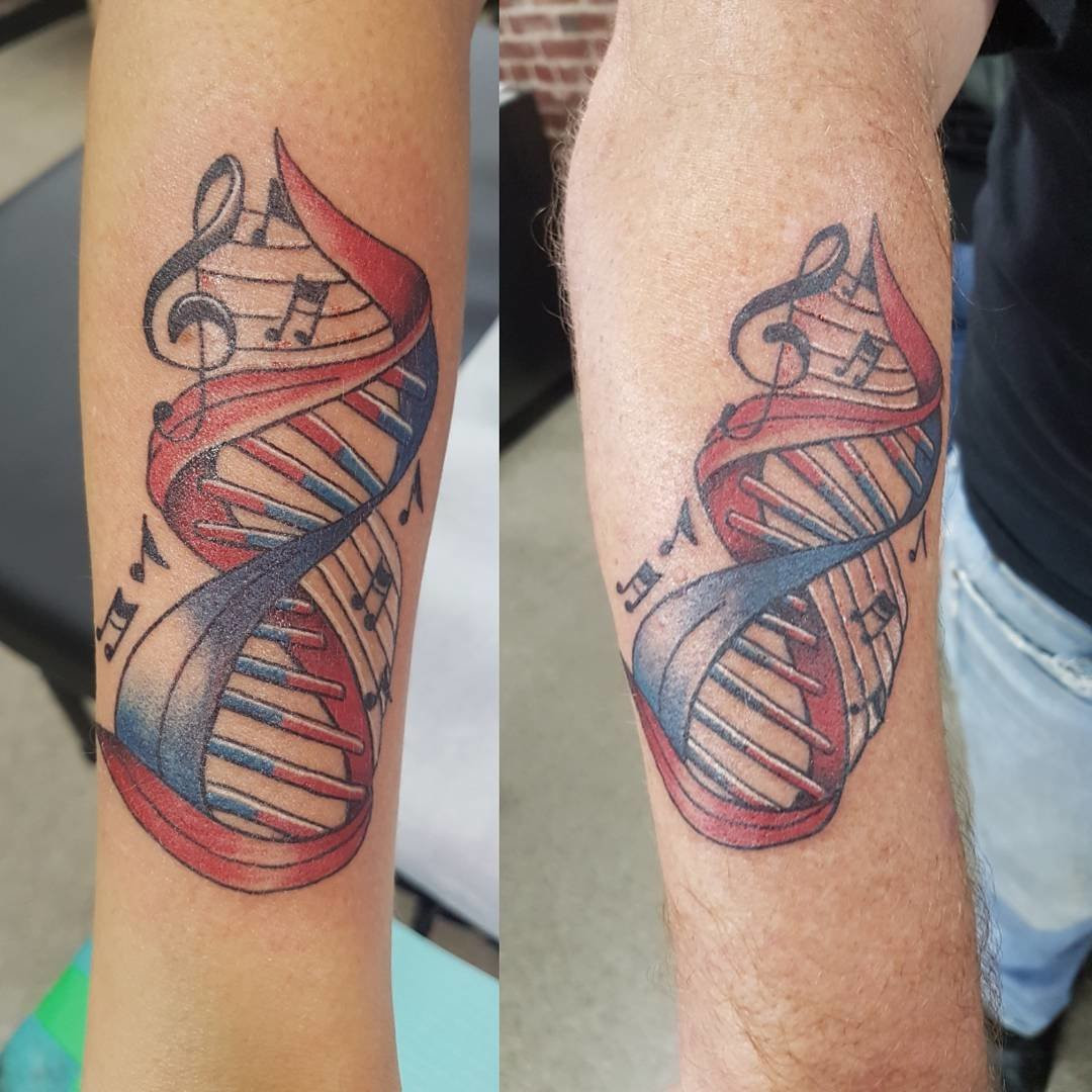 Father and daughter displaying forearm tattoos of music notes and DNA strands intertwined, symbolizing their shared love for music and genetic connection.