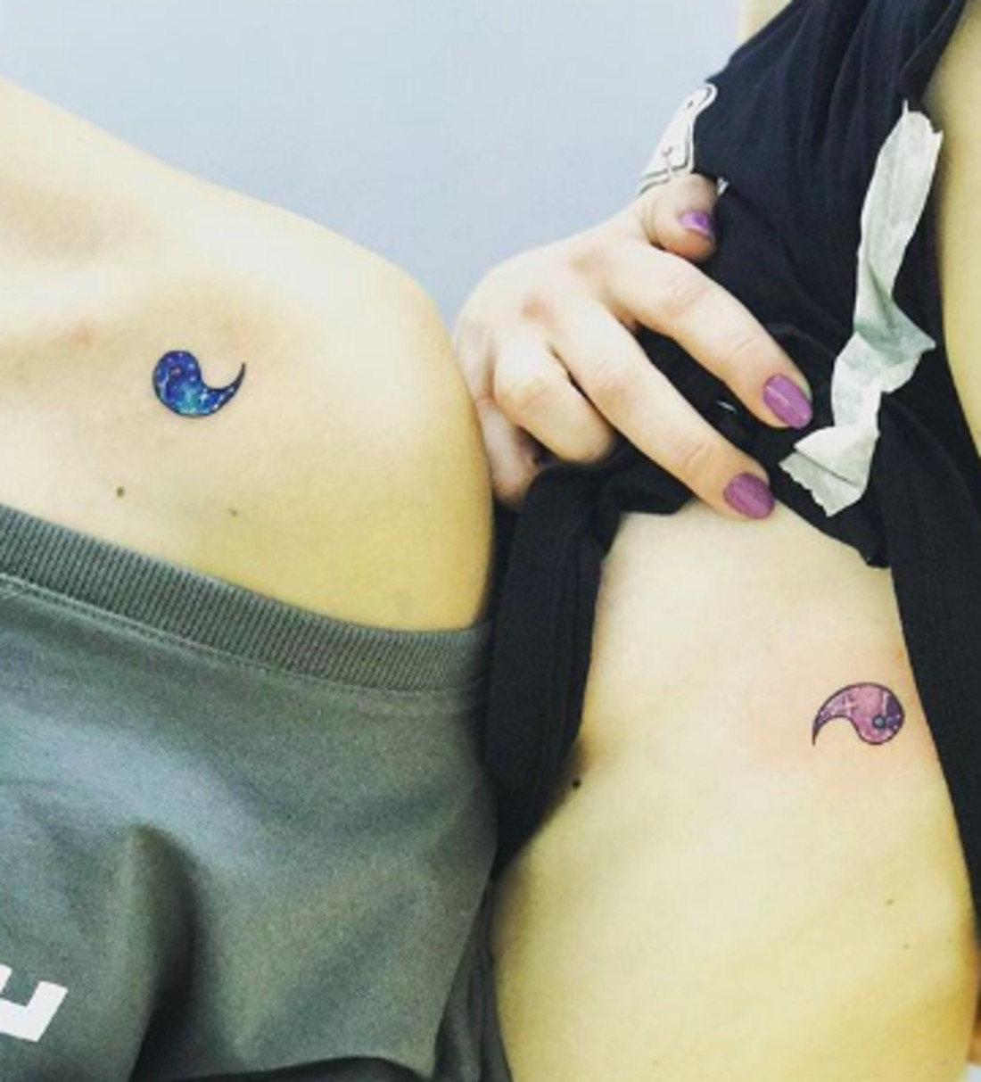 Yin and yang symbol tattoos filled with galaxy designs, representing balance and cosmic friendship