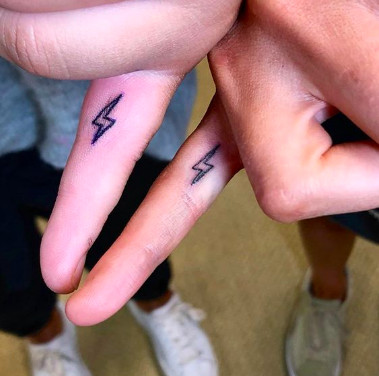 Simple black lightning bolt tattoos on fingers, representing a striking and energetic friendship