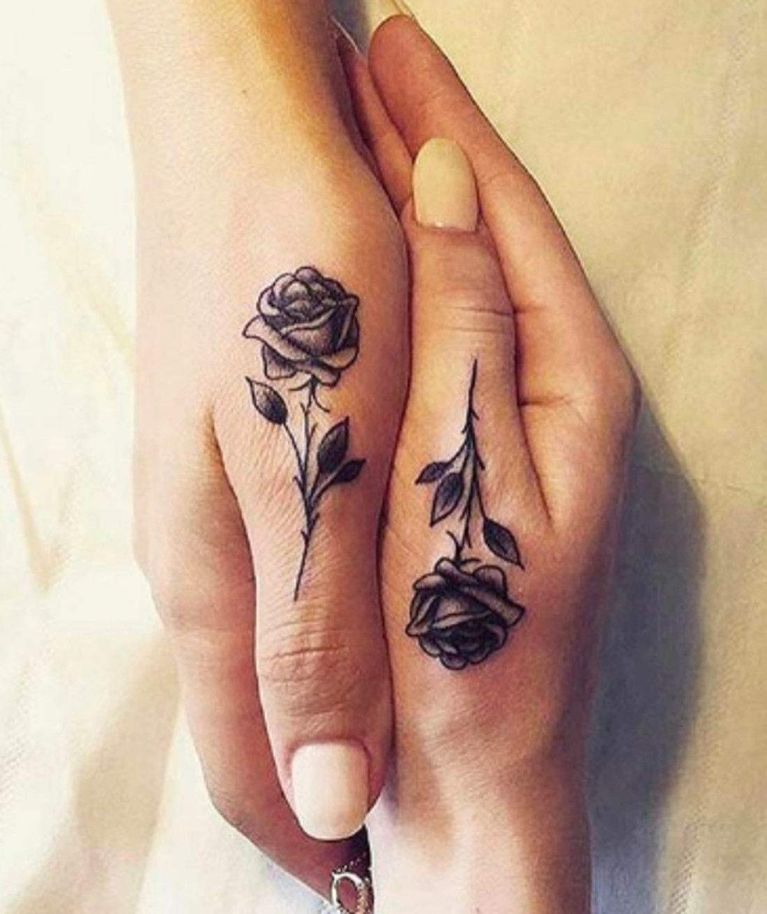 Small shaded rose tattoos, representing classic beauty and enduring friendship