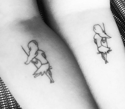 Matching tattoos of a girl on a swing, representing childhood memories and shared life journey