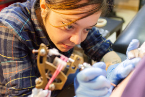 Cecilia Granata tattooing someone's arm