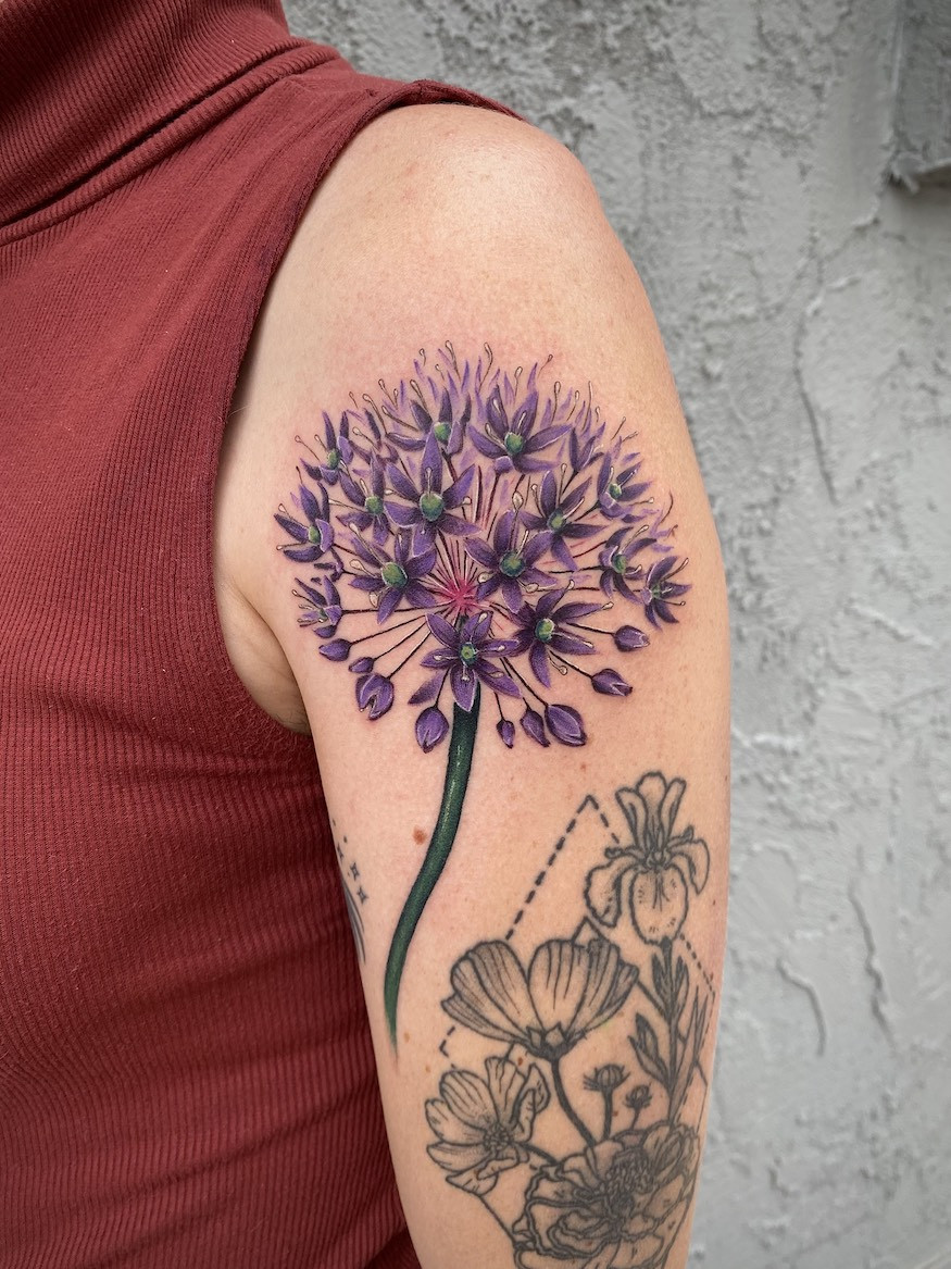 Inner arm tattoo of a detailed peony flower with soft shading, exemplifying popular feminine floral tattoo choices.