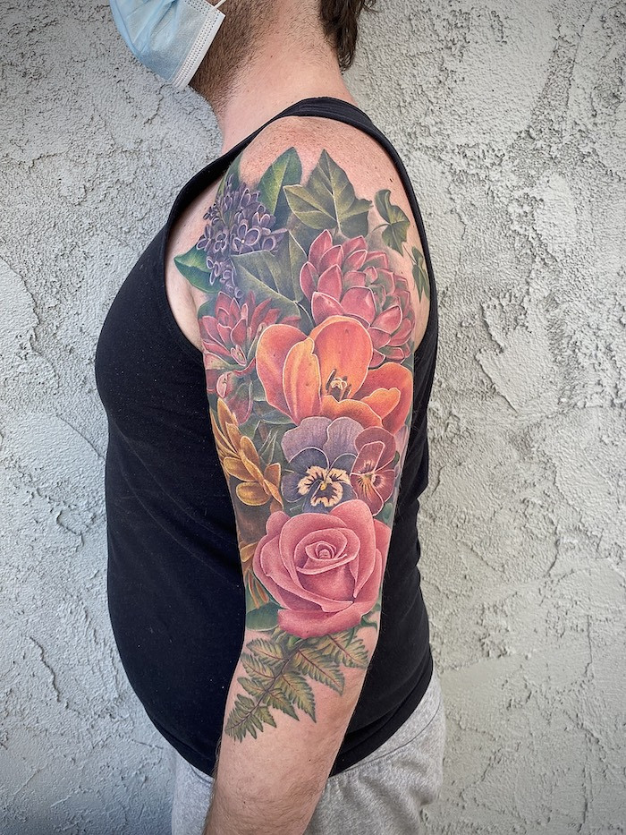 Detailed black and gray rose tattoo on a hand, exemplifying realism in feminine tattoo art.