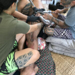 Kiha Rodrigues undergoing the traditional Hawaiian tattooing process of kākau, showcasing the hand-tapping method