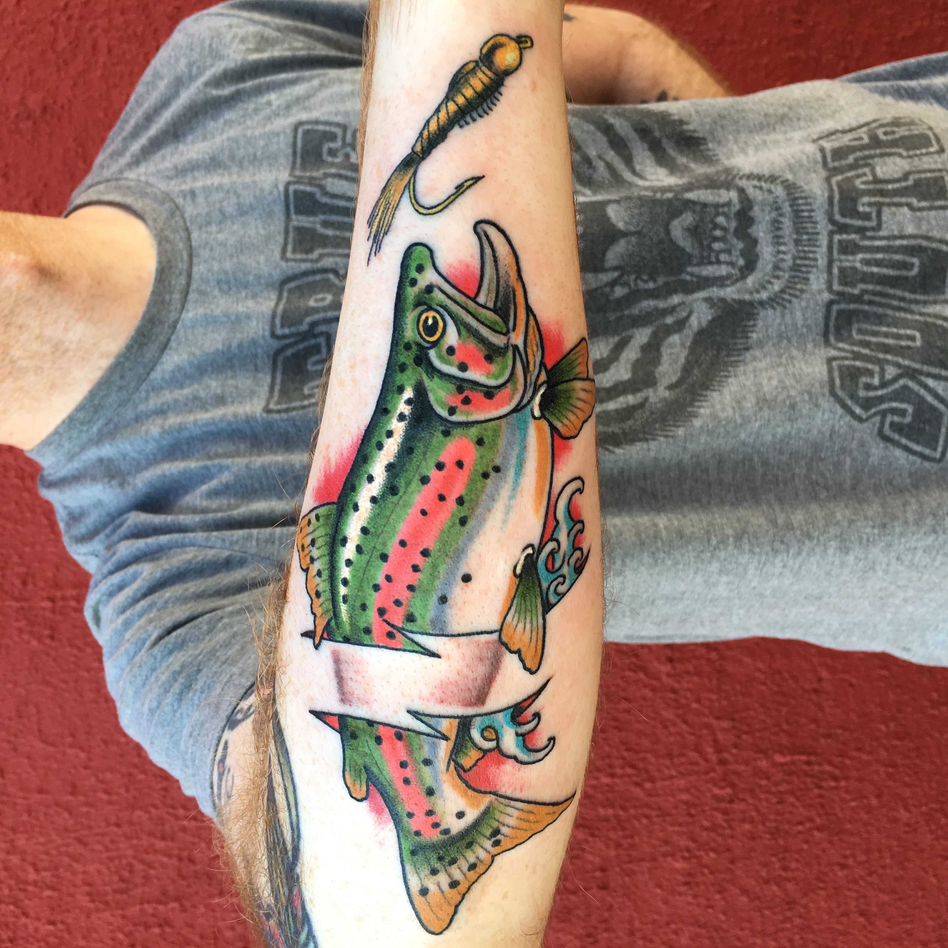 Drew Wilson's signature bold style in a fly fishing tattoo, highlighting the intricate scales and fins of a fish.