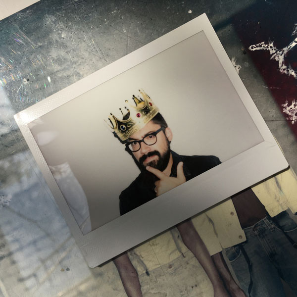 Clayton Cubitt wearing a crown, studio portrait