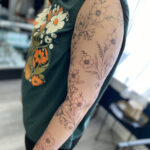 Intricate fine line tattoo of floral elements on an arm by Mike Brown, Stay True Tattoo.