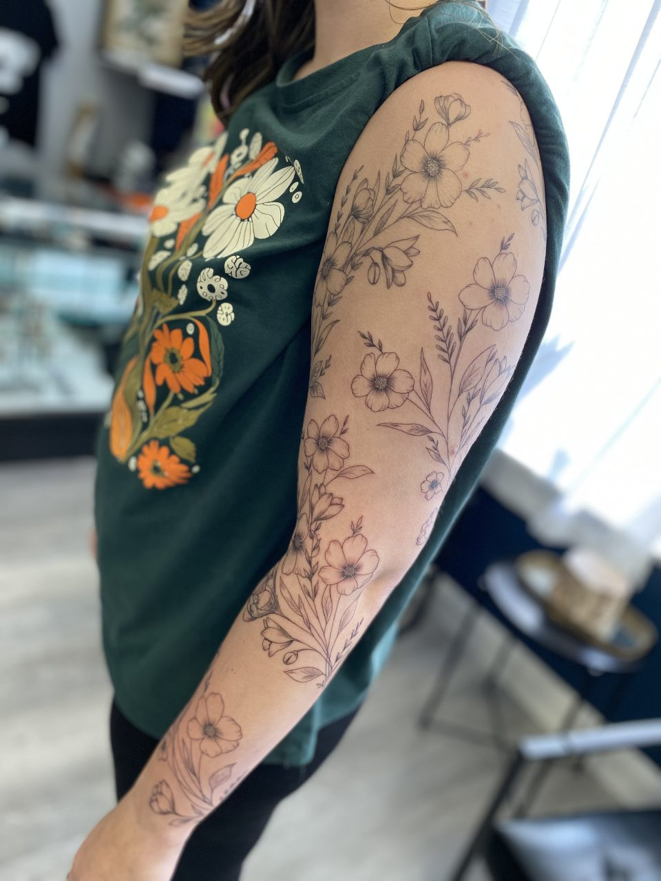 Intricate fine line tattoo of floral elements on an arm by Mike Brown, Stay True Tattoo.