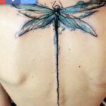 A mother and son showcasing their matching dragonfly tattoos, a symbol of their bond.