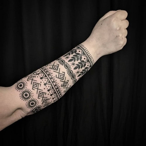 Indian tribal tattoo on a man's arm, showcasing patterns and motifs inspired by Indian tribal art.