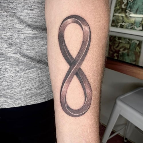 Infinity symbol tattoo on the wrist, representing eternity in men tattoo ideas.